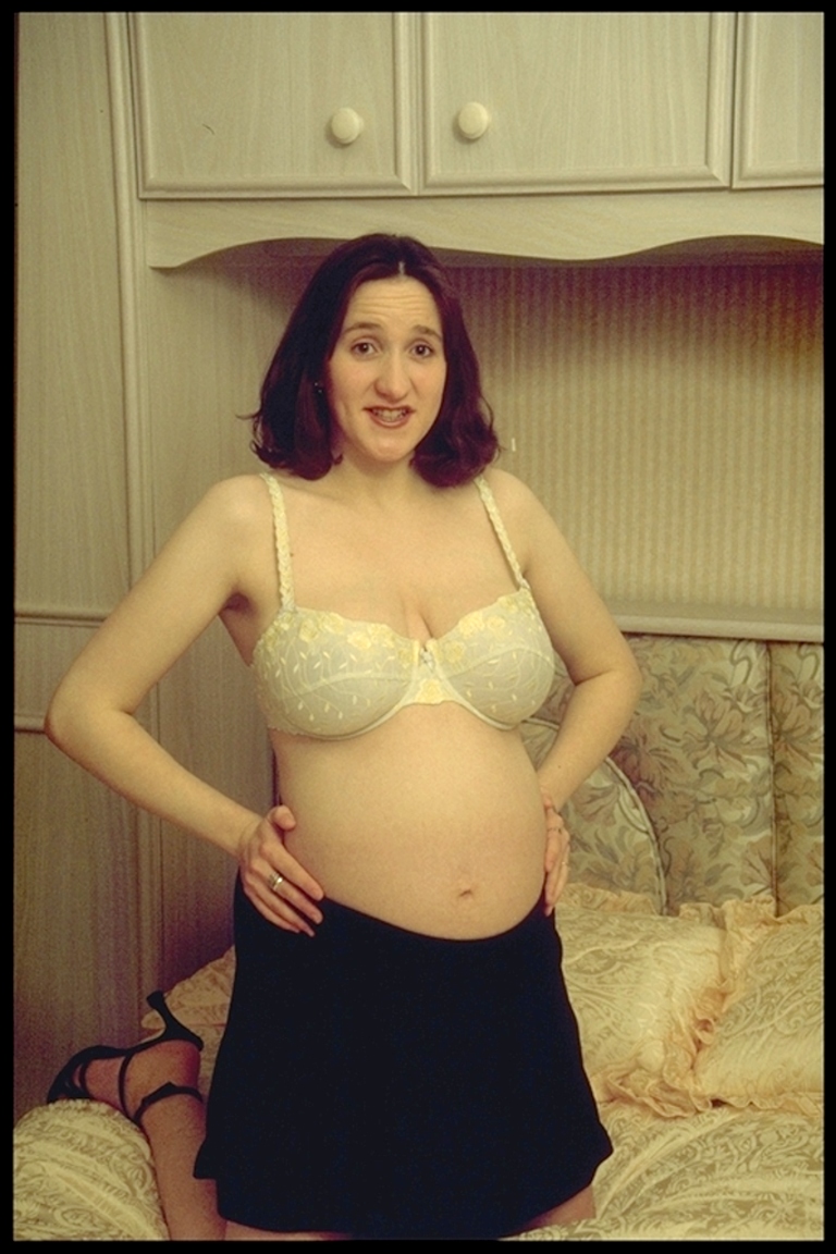 Schwangere in BH zeigt Babybauch